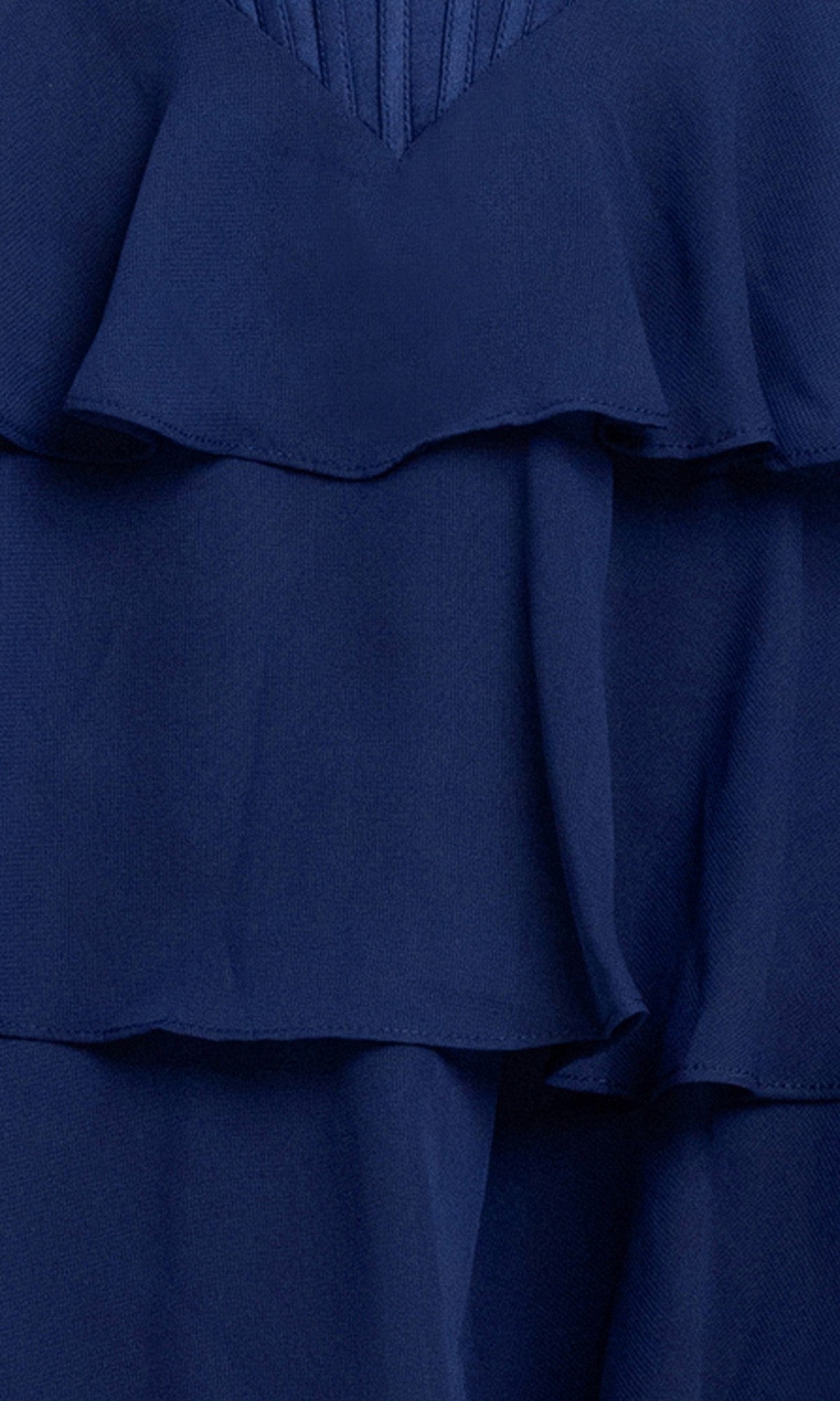Close-up of layered navy blue fabric with ruffled edges and pleated texture from the Ruffled Mini Hoco Dress: Blondie Nites 6222BN, highlighting details of this short homecoming dress.